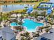 Aerial view of community pool with palm trees, cabanas, lounge chairs, and lush landscaping near lake at 6248 Fish Eagle Ct, Nokomis, FL 34275
