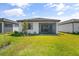Well-maintained back exterior showing lush green grass, covered patio, and the home's clean, modern architecture at 6248 Fish Eagle Ct, Nokomis, FL 34275