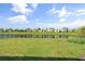 Lush backyard with a pond view featuring well-maintained grass and palm trees for a peaceful setting at 6248 Fish Eagle Ct, Nokomis, FL 34275