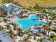 Aerial view of a resort-style pool with lush landscaping, lounge areas, and clubhouse at 6248 Fish Eagle Ct, Nokomis, FL 34275