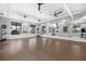 Bright gym area with wall mirrors, hardwood floors, and multiple ceiling fans at 6248 Fish Eagle Ct, Nokomis, FL 34275
