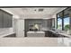 Community kitchen equipped with stainless steel appliances, custom gray cabinets, and a center island with granite countertops at 6248 Fish Eagle Ct, Nokomis, FL 34275