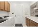 Functional laundry room with washer, dryer, cabinetry, and ample storage space at 6248 Fish Eagle Ct, Nokomis, FL 34275