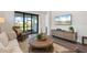 Bright living room features wood floors, a decorative rug, a large TV, and sliding glass doors with a peaceful view at 6248 Fish Eagle Ct, Nokomis, FL 34275