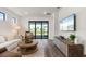 Bright living room features wood floors, a decorative rug, a large TV, and sliding glass doors with a lovely view at 6248 Fish Eagle Ct, Nokomis, FL 34275