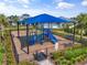 Aerial view of the community playground with safety features, surrounded by lush greenery and palm trees at 6248 Fish Eagle Ct, Nokomis, FL 34275