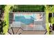 Overhead shot of a screened pool with an attached spa, patio furniture, and well-maintained backyard at 6290 Mesa Gln, Bradenton, FL 34203