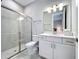 Bathroom features a glass-enclosed shower, white cabinets, and a view to a bedroom at 6290 Mesa Gln, Bradenton, FL 34203
