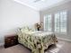 Bedroom with patterned bedding, neutral walls, and a window with shutters at 6290 Mesa Gln, Bradenton, FL 34203