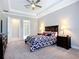 Primary bedroom featuring a tray ceiling, neutral tones, carpeting, and a view to the Primary bathroom at 6290 Mesa Gln, Bradenton, FL 34203