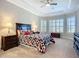 Primary bedroom featuring a tray ceiling, carpeting, and a window with shutters at 6290 Mesa Gln, Bradenton, FL 34203