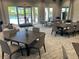 Clubhouse interior featuring lounge areas, dining tables, and a ping pong table with pool view at 6290 Mesa Gln, Bradenton, FL 34203