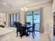 Dining room with black table and chairs, sliding doors offer a pool view at 6290 Mesa Gln, Bradenton, FL 34203