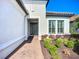 Inviting entryway of a home with a brick walkway, manicured landscaping, and a dark wood front door at 6290 Mesa Gln, Bradenton, FL 34203