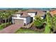 Attractive single-Gathering home featuring a tile roof, attached garage, brick driveway, and meticulous landscaping at 6290 Mesa Gln, Bradenton, FL 34203