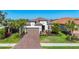 Beautiful single-Gathering home with a tile roof, attached garage, brick driveway, and well-manicured lawn at 6290 Mesa Gln, Bradenton, FL 34203