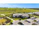 Aerial view of the home's exterior showcasing the lush green landscape, a parking lot, and the architecture at 6290 Mesa Gln, Bradenton, FL 34203