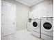 Functional laundry area featuring white cabinetry, modern washer and dryer set, and light tile floor at 6290 Mesa Gln, Bradenton, FL 34203