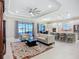Open-concept living room with modern furniture, tray ceiling, and access to the outdoor patio at 6290 Mesa Gln, Bradenton, FL 34203