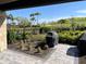 Backyard patio with outdoor grill, beautiful landscaping, and views of green space at 6290 Mesa Gln, Bradenton, FL 34203
