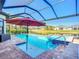 Screened in pool has attached spa, sun umbrella, and gorgeous views of the green space and lake at 6290 Mesa Gln, Bradenton, FL 34203
