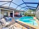 Screened in pool has attached spa and a fire pit, with outdoor seating and a sun umbrella at 6290 Mesa Gln, Bradenton, FL 34203
