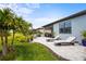 Backyard view with lounge chairs, a grill, lush greenery, and outdoor living spaces at 6295 Crested Eagle Ln, Nokomis, FL 34275