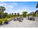 Outdoor area with BBQ, a firepit, seating and well maintained pavers and green plants around the area at 6295 Crested Eagle Ln, Nokomis, FL 34275