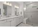 Bright bathroom featuring double sinks, white cabinetry, a glass-enclosed shower, and modern fixtures at 6295 Crested Eagle Ln, Nokomis, FL 34275