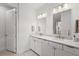 Clean bathroom featuring double sinks, white cabinets, modern fixtures, and a neutral color palette at 6295 Crested Eagle Ln, Nokomis, FL 34275