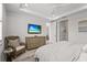 Bedroom with a comfortable bed, a TV, and a cozy wicker chair, offering a relaxing retreat at 6295 Crested Eagle Ln, Nokomis, FL 34275