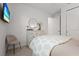 Bright bedroom with white walls, a round mirror above a dresser, and a television on the wall at 6295 Crested Eagle Ln, Nokomis, FL 34275