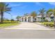 Exterior view of a modern clubhouse featuring manicured landscaping and ample parking at 6295 Crested Eagle Ln, Nokomis, FL 34275