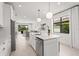 Open-concept kitchen features an island with a sink, stainless steel appliances, and backyard views at 6295 Crested Eagle Ln, Nokomis, FL 34275