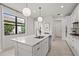 Bright kitchen features a center island with modern pendant lights at 6295 Crested Eagle Ln, Nokomis, FL 34275