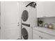 A tidy laundry room features a stacked washer and dryer with modern appliances and ample counter space at 6295 Crested Eagle Ln, Nokomis, FL 34275