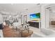 Open-concept living room with modern decor, large TV, stylish furniture, and a view of the kitchen and dining area at 6295 Crested Eagle Ln, Nokomis, FL 34275