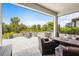 An inviting outdoor patio features comfortable seating, a built-in grill, and lush tropical landscaping at 6295 Crested Eagle Ln, Nokomis, FL 34275