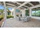 Charming outdoor seating area with a fireplace, ceiling fans, and views of lush landscaping at 6295 Crested Eagle Ln, Nokomis, FL 34275