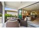 Inviting covered patio with wicker seating, open access to the indoor living space, and outdoor views at 6295 Crested Eagle Ln, Nokomis, FL 34275