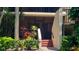 Close-up of a condo entrance with a screen door, tropical plants, and stairs at 6462 Wild Oak Bay Blvd # 245, Bradenton, FL 34210