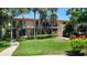 Condominium building with balconies, a manicured lawn, and mature palm trees at 6462 Wild Oak Bay Blvd # 245, Bradenton, FL 34210