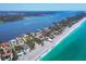 Stunning aerial view of waterfront homes along the coast with clear blue ocean and lush greenery at 7985 Manasota Key Rd, Englewood, FL 34223