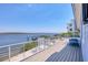 Beautiful water view from a large balcony with white metal railing and an outdoor dining set at 7985 Manasota Key Rd, Englewood, FL 34223
