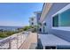 Large balcony with beautiful water views, white metal railing, and outdoor dining furniture at 7985 Manasota Key Rd, Englewood, FL 34223