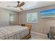 A cozy bedroom features neutral walls, natural light, and a ceiling fan at 7985 Manasota Key Rd, Englewood, FL 34223
