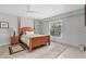 Neutral bedroom with a four poster bed, tile floors, and large window at 7985 Manasota Key Rd, Englewood, FL 34223
