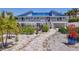 A home with a blue metal roof boasts manicured landscaping and a stone walkway at 7985 Manasota Key Rd, Englewood, FL 34223
