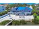 Stunning waterfront home featuring a vibrant blue roof, spacious patio, and direct access to the water for kayaking and leisure at 7985 Manasota Key Rd, Englewood, FL 34223