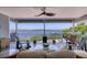 Spacious outdoor porch with ceiling fan, comfortable seating, and panoramic waterfront views at 7985 Manasota Key Rd, Englewood, FL 34223